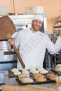 快乐的面包师微笑在相机上职业厨师男性酒店餐饮制服托盘工作厨房职员图片