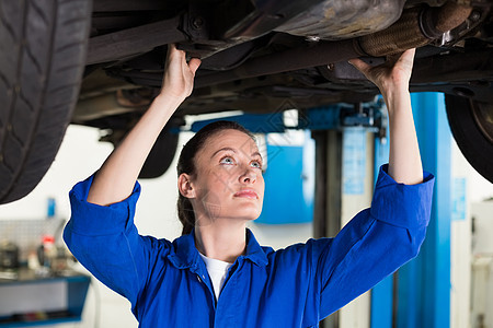 汽车下面的机械检查女性服务车辆女士作坊机械师工作服工人车库工程师图片