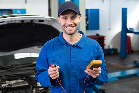 机械人微笑在相机的握着工具机械机械师修复汽车兜帽男性车辆作坊蓝色工程师图片