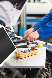 在车上使用膝上型计算机的机械职业技术兜帽服务修复机械师工人笔记本引擎盖诊断图片