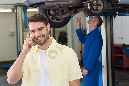 客户打来电话沟通机械师工程师汽车蓝色手机男性工作服车库作坊图片