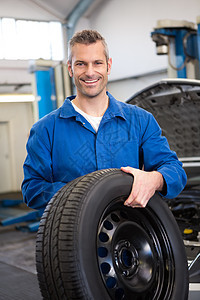 手持轮胎轮机的机械师男性工程师工人车轮男人引擎盖车辆修理工作服汽车图片