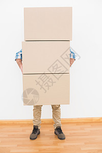 男子携带一堆纸板搬运箱图片