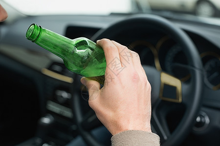 人开车时喝啤酒驾驶瓶子闲暇汽车啤酒酒后驾车致命运输零件男性图片