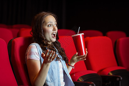 年轻女性看电影活动闲暇座位演出时间椅子快乐礼堂电影微笑图片