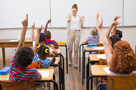 教师在课堂上提供数学课的教学男生职业桌子混血互动女孩班级微笑女士教育图片