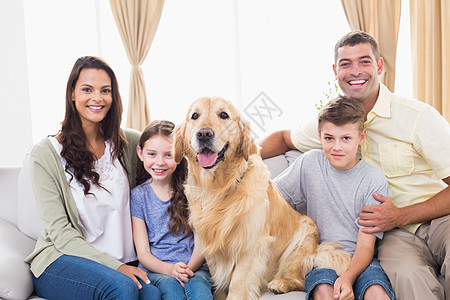 幸福的一家人坐在沙发上与金子一起图片