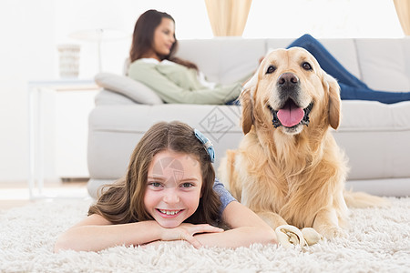 带着狗的女孩躺在地毯上图片