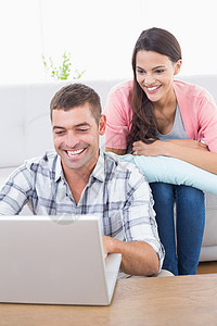 夫妇一起使用笔记本电脑男人技术休息室女士沙发客厅家庭生活夫妻女性男性图片