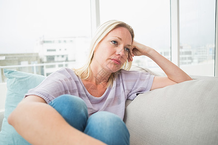 坐在沙发上的可怜女人金发下巴休息室金发女郎悲伤表情浅色思维成人长发图片