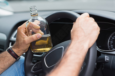 男人在开车时喝酒生命汽车致命方向盘男性瓶子零件酒后驾车驾驶运输图片