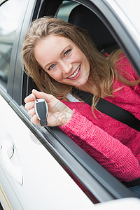 年轻女人笑着拿着钥匙安全带窗户闲暇享受代理商公路陆地女士快乐车辆图片