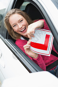 学生驾驶员笑着拿着盘子运输l板享受旅行快乐闲暇司机女性汽车陆地图片