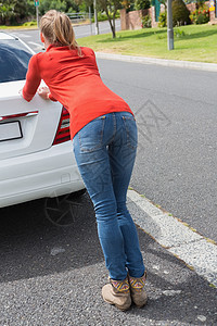 年轻女人推她撞坏的车女士女性运输空罐公路汽车发动机闲暇司机旅行图片