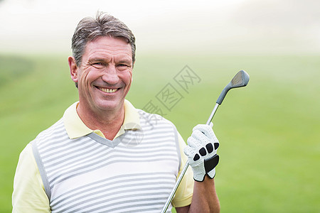 欢快的高尔夫球手在镜头前微笑 抱着他的俱乐部绿色运动员老年运动男人高尔夫球爱好服装闲暇时间图片