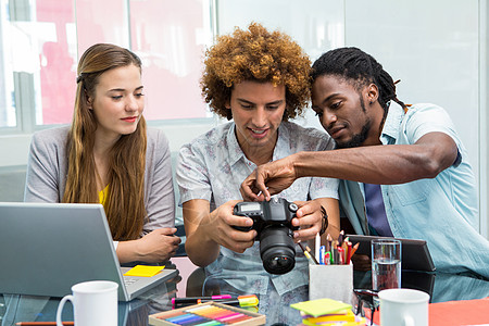 创意青年商业人士观看数码相机的创意青年专业设计电脑工作头脑摄影师合作职场团队工作室图片