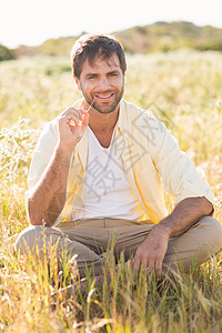 快乐的男子在镜头中微笑服装草地环境男人绿地闲暇休闲农村家庭生活衬衫图片