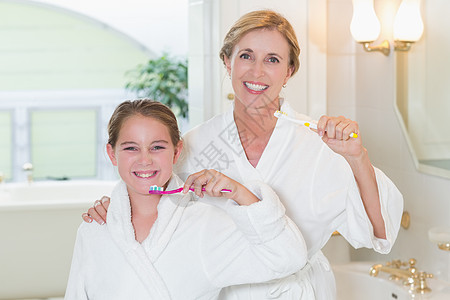 每日一起幸福的母亲和女儿一起刷牙的快乐母亲和女儿浴室家庭房子孩子金发女郎卫生女孩女性微笑公寓背景