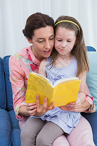 母亲和女儿阅读书女儿客厅服装房子家庭公寓闲暇女孩女性棕色图片