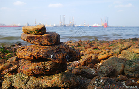 海洋沿岸的岩石卵石海滩船厂石头棕色蓝色天空海藻图片