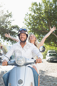 迷人的情侣骑摩托车闲暇感情助力车活动乐趣方式夫妻金发女郎交通浅色背景图片