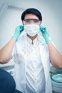 戴外科面罩和安全眼镜的牙医口腔科手套口罩诊所短发手术牙科专业女士女性图片