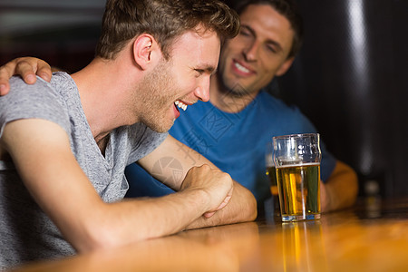 快乐的朋友们追上品脱朋友酒吧男性男人酒精互动讨论休闲啤酒友谊图片