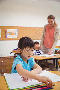 在课堂桌上写字的可爱学生黑板小学笔记本童年同学们教育班级椅子男性小学生图片