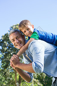 父子在公园玩得开心环境团结微笑树木闲暇幸福绿地肩膀儿子男性图片