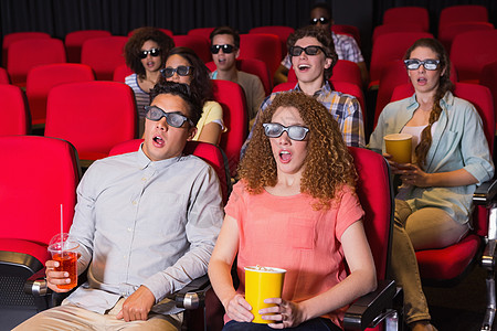年轻朋友在看一部3D电影震惊女孩文艺活动女性演出男人青少年礼堂座位图片