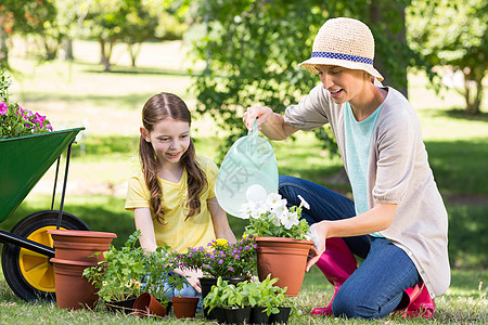 金发快乐和女儿的园艺母亲闲暇男性花盆活动生长花园孩子帽子草地图片