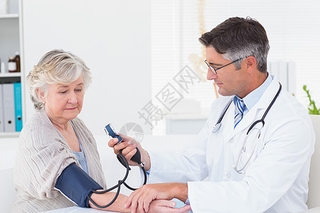 检查女性病人血压的医生;图片