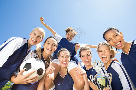 漂亮的足球运动员在镜头中微笑友谊运动绿地活动女性阳光快乐闲暇欢呼活力图片