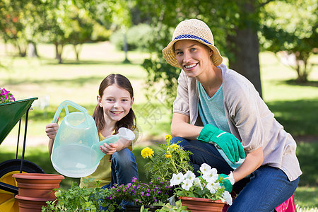 金发快乐和女儿的园艺植物女性母亲花盆孩子土地帽子男性帮助活动图片