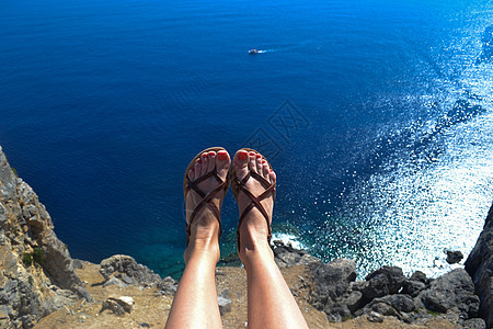 女人坐在顶端 双腿在海面上 蓝色的漂亮颜色图片