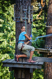 女孩在一个攀登冒险公园喜悦操场挑战孩子公园闲暇力量绳索森林危险图片