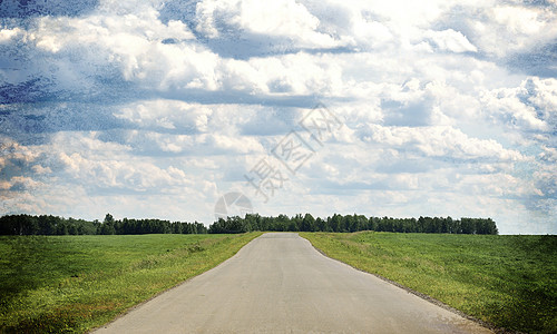 旧路 道路支线和绿草地 背景有云的天空图片