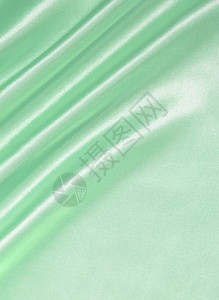 平滑优雅的绿色丝绸或作为背景的沙子涟漪布料折叠纺织品曲线海浪窗帘折痕银色柔软度图片