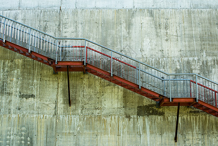 灰水泥墙上的金属楼梯水泥石墙石头建筑护栏石膏对角线平台扶手梯子图片