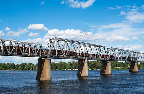 基辅的铁路桥梁横跨第尼佩尔河 配有货运列车交通车皮建造跨度梯形格子商品码头货物桁架图片