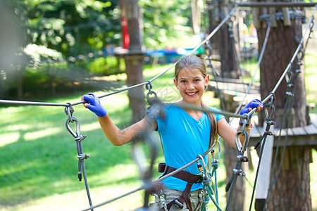 女孩在一个攀登冒险公园运动高度头盔成功活动自由森林绳索探索力量图片