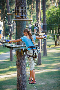 女孩在一个攀登冒险公园挑战闲暇绳索风险行动勇气探索喜悦森林青少年图片
