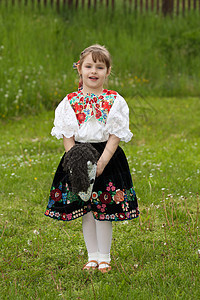 小女孩在草地上玩耍乐趣民俗节日农鞋微笑花朵国家游戏绣花女孩图片