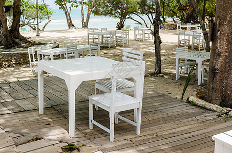 白椅子和白桌天堂假期旅行木头休息室海岸场景桌子海岸线海洋图片