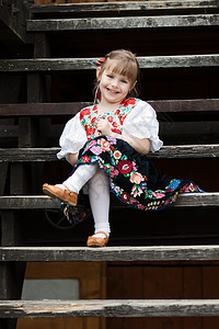穿着传统服装的坐着小女孩戏服花朵地区农鞋文化节日楼梯裙子女性喜悦图片