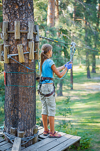 女孩在一个攀登冒险公园挑战高度行动操场冒险青少年运动探索活动绳索图片