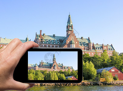 女性手与智能手机拍摄斯德哥尔摩拱门照片图片
