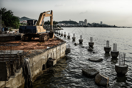 将陆地扩大到海洋岩石地面工作土地工程石头海浪彩旗背景图片