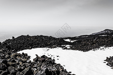 Etna山峰 雪和火山岩 意大利西西里沮丧石头地质学火山流动旅行岩石地标顶峰假期图片