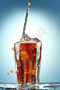 倒在玻璃杯里的可乐水晶生活果汁庆典蓝色苏打飞溅流动饮料玻璃图片